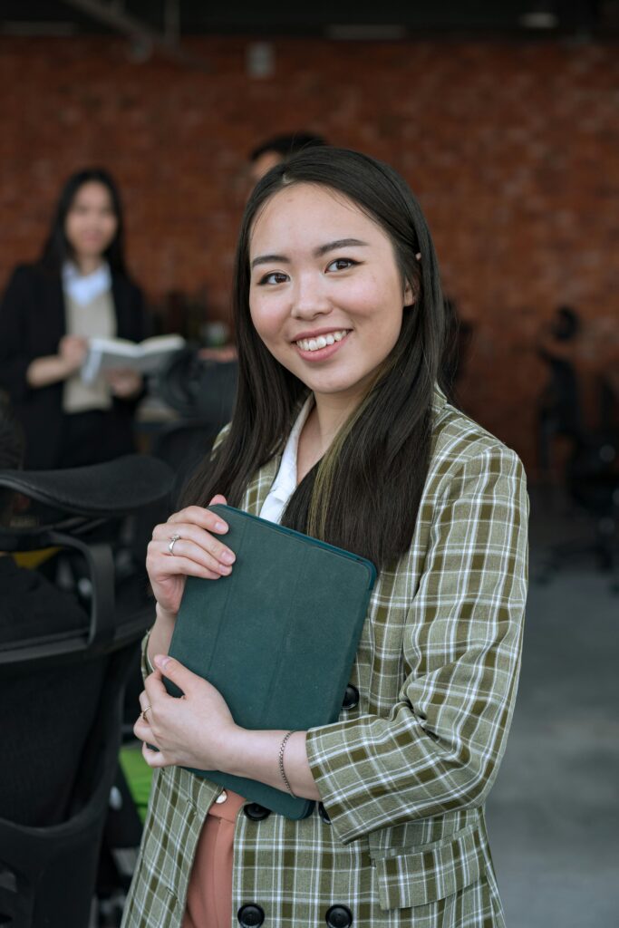 Cheerful businesswoman with a tablet in a modern office setting.
